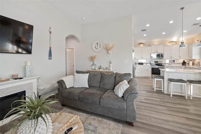 1286 Lagoon Dr, Crystal Beach, TX 77650 - living area with light wood-style flooring, arched walkways, recessed lighting, and a fireplace