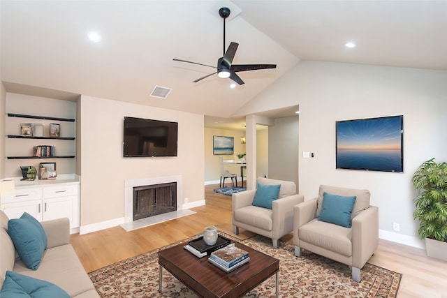 living room with light hardwood / wood-style floors, lofted ceiling, and ceiling fan