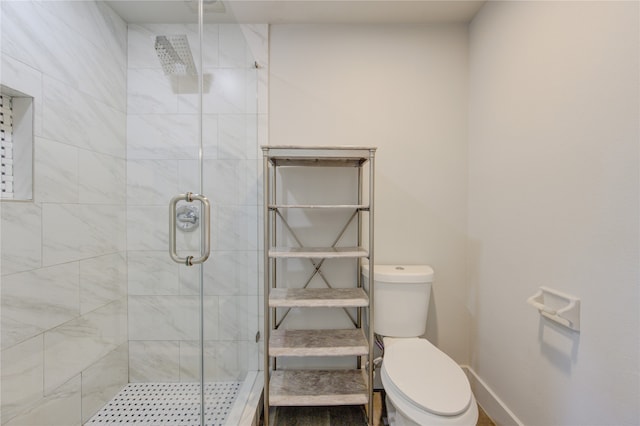 bathroom featuring a shower with shower door and toilet