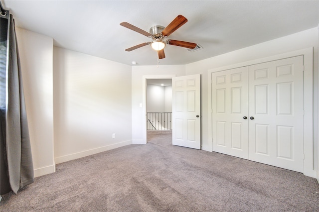 unfurnished bedroom with ceiling fan, carpet flooring, and a closet