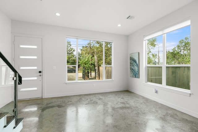 foyer with concrete flooring and a healthy amount of sunlight