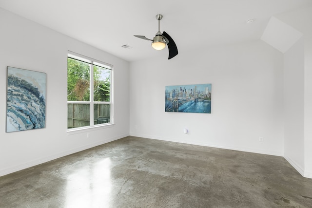 unfurnished room with lofted ceiling, ceiling fan, and concrete floors