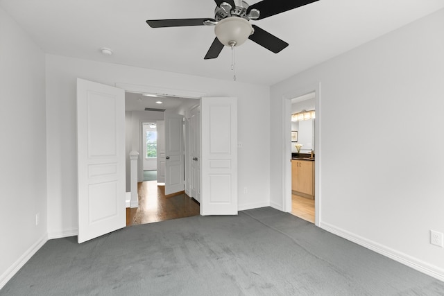 unfurnished bedroom featuring ensuite bathroom, ceiling fan, and dark hardwood / wood-style floors