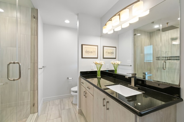 bathroom featuring toilet, vanity, and an enclosed shower