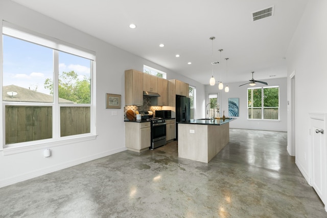 kitchen featuring a center island with sink, gas range, tasteful backsplash, ceiling fan, and pendant lighting