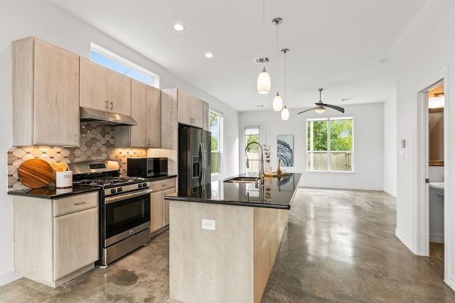 kitchen with fridge with ice dispenser, sink, an island with sink, stainless steel range with gas cooktop, and pendant lighting