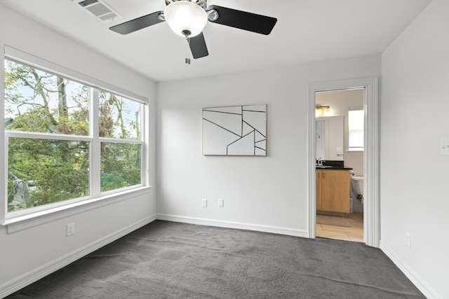 spare room with sink, ceiling fan, and carpet floors