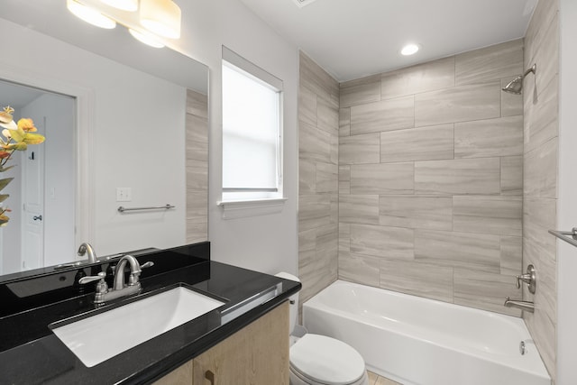 full bathroom featuring vanity, toilet, and tiled shower / bath combo