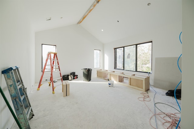 recreation room with beamed ceiling, light carpet, and high vaulted ceiling