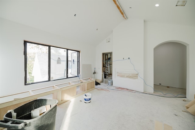 interior space with carpet, beamed ceiling, and high vaulted ceiling