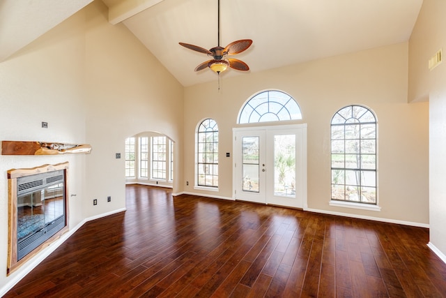 unfurnished living room featuring dark hardwood / wood-style floors, high vaulted ceiling, ceiling fan, and a healthy amount of sunlight