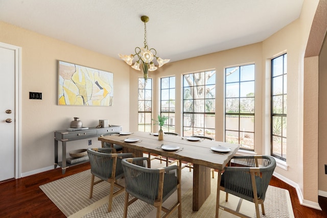 dining area featuring a chandelier, dark wood-type flooring, and a healthy amount of sunlight