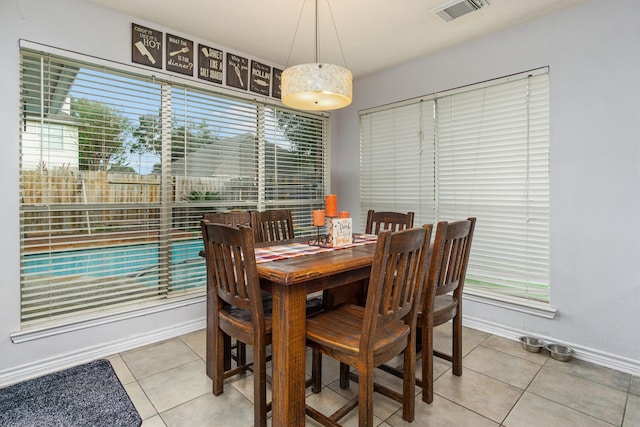 tiled dining room featuring a healthy amount of sunlight