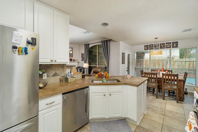 kitchen featuring white cabinetry, kitchen peninsula, appliances with stainless steel finishes, and sink