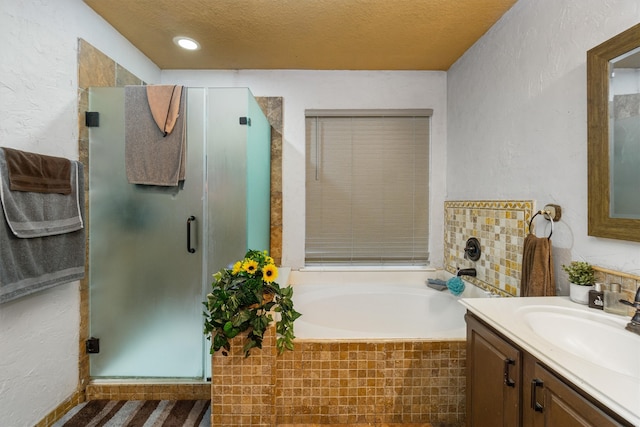 bathroom featuring vanity, a textured ceiling, and independent shower and bath