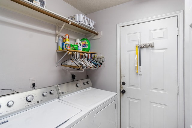 clothes washing area featuring washing machine and clothes dryer and a textured ceiling