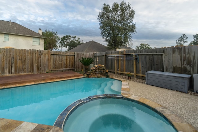 view of swimming pool with an in ground hot tub