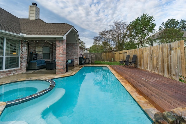 view of swimming pool featuring an in ground hot tub and a deck