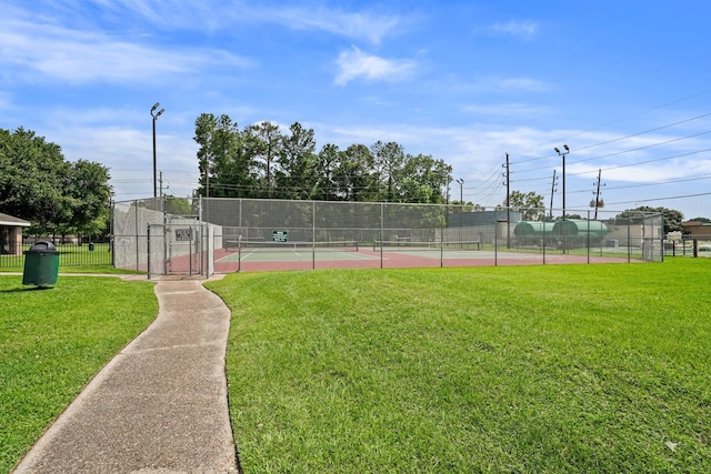 view of tennis court featuring a yard