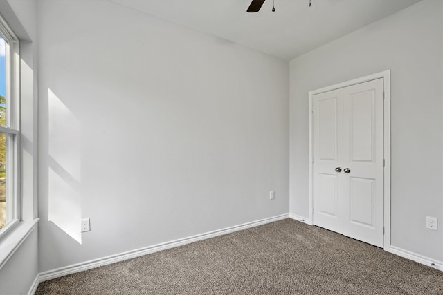 carpeted spare room featuring ceiling fan