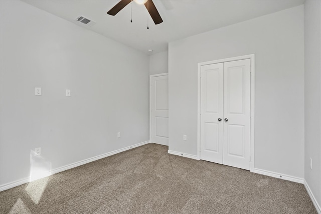 unfurnished bedroom with ceiling fan, a closet, and carpet