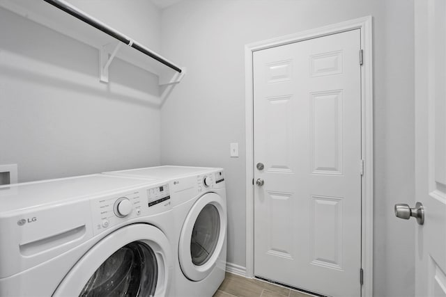 laundry room featuring washing machine and dryer and light tile patterned floors