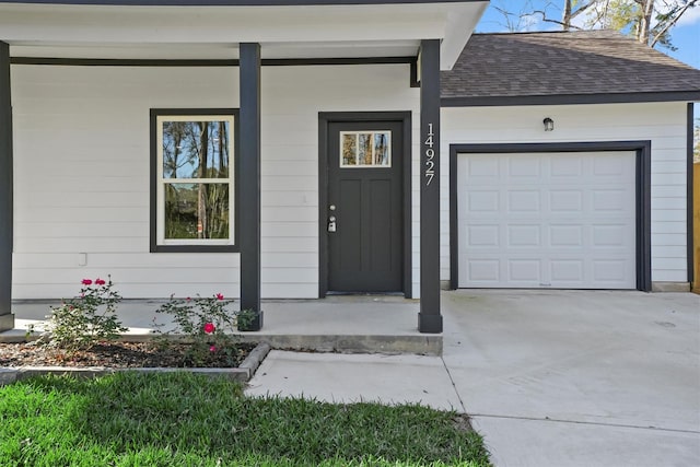 doorway to property with a porch and a garage