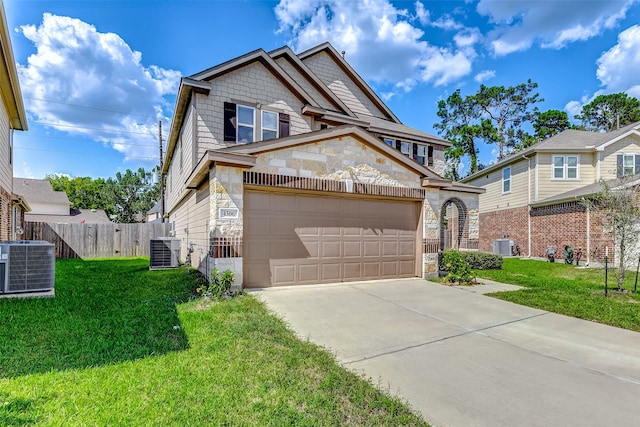 view of front of home with a garage, a front lawn, and central AC