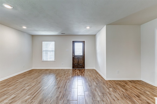 entrance foyer featuring a textured ceiling and light hardwood / wood-style flooring