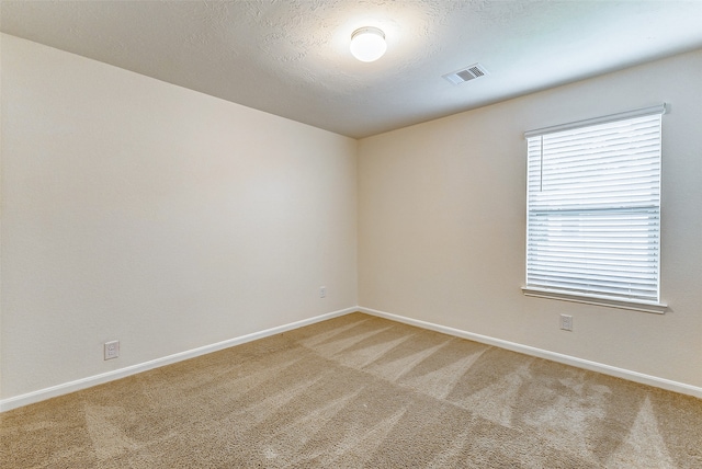 spare room featuring carpet and a textured ceiling