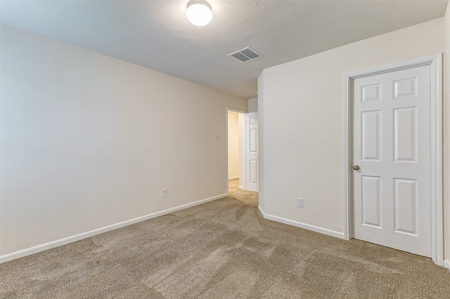 spare room with a textured ceiling and carpet floors