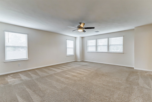 unfurnished room with light colored carpet and ceiling fan