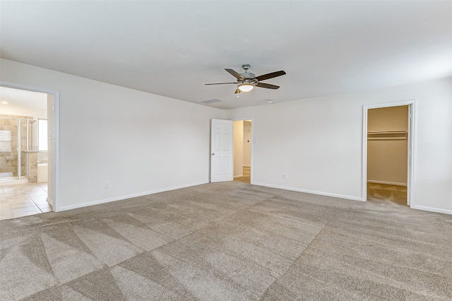 interior space featuring ensuite bath, light carpet, ceiling fan, a spacious closet, and a closet