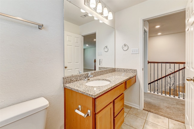 bathroom with tile patterned flooring, vanity, and toilet