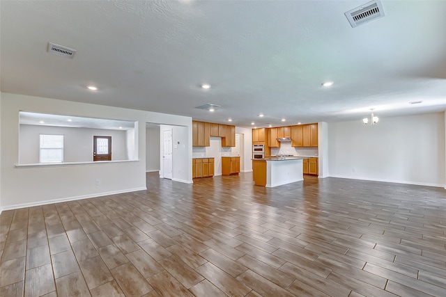 unfurnished living room featuring hardwood / wood-style floors and an inviting chandelier