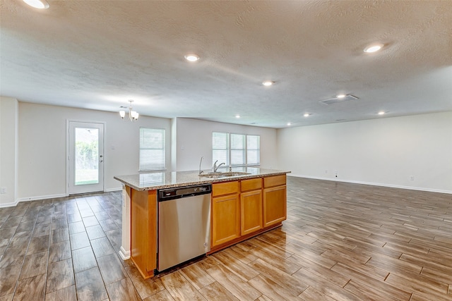 kitchen featuring dishwasher, light wood-type flooring, a kitchen island with sink, and a healthy amount of sunlight