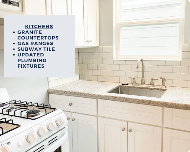 kitchen featuring white cabinets, sink, tasteful backsplash, white gas stove, and light stone countertops