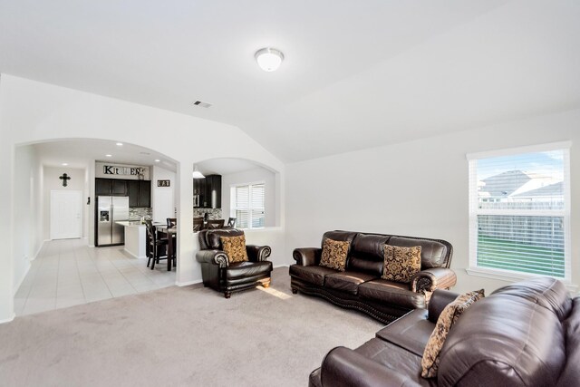 carpeted living room with vaulted ceiling