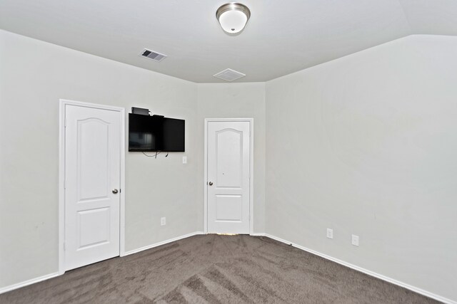 carpeted spare room featuring vaulted ceiling