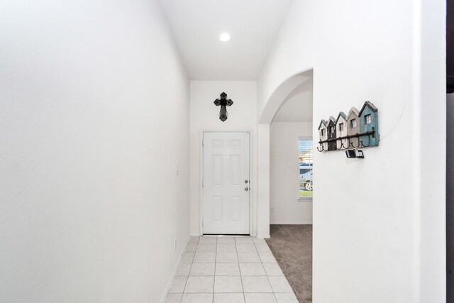 corridor with light colored carpet and lofted ceiling