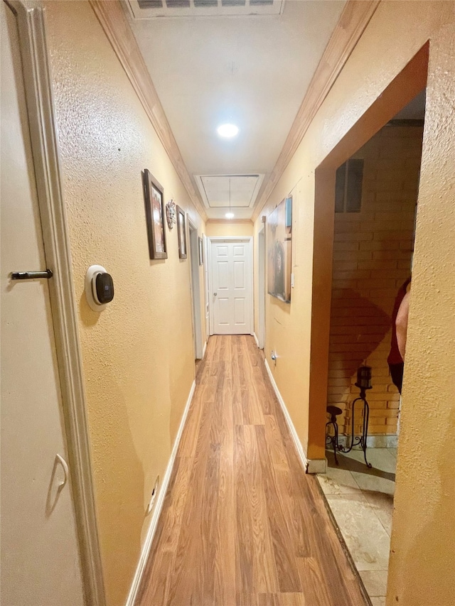 corridor featuring wood-type flooring, crown molding, and a tray ceiling