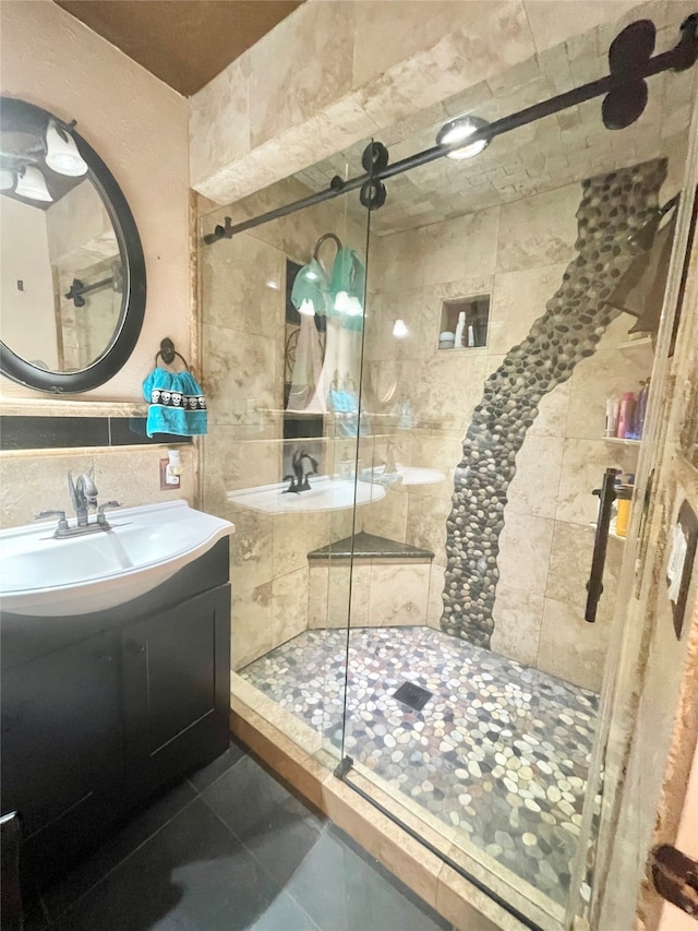 bathroom with vanity, an enclosed shower, and tile walls