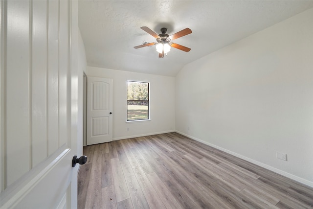 unfurnished room featuring ceiling fan, light hardwood / wood-style floors, and lofted ceiling