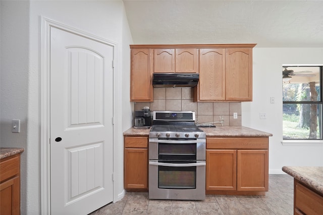 kitchen with tasteful backsplash, ceiling fan, and stainless steel gas stove