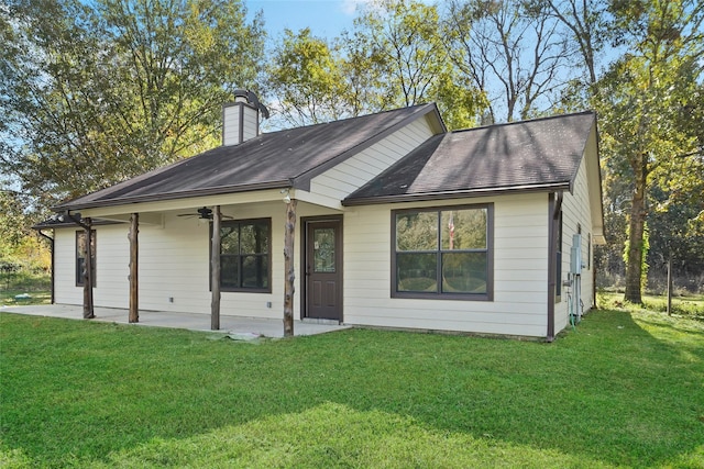 single story home featuring ceiling fan, a patio area, a front lawn, a chimney, and a shingled roof