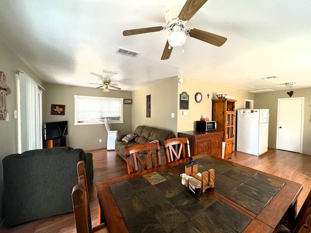 dining space with dark hardwood / wood-style flooring and ceiling fan