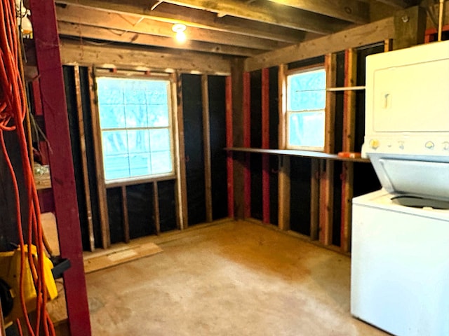 basement featuring stacked washer and clothes dryer