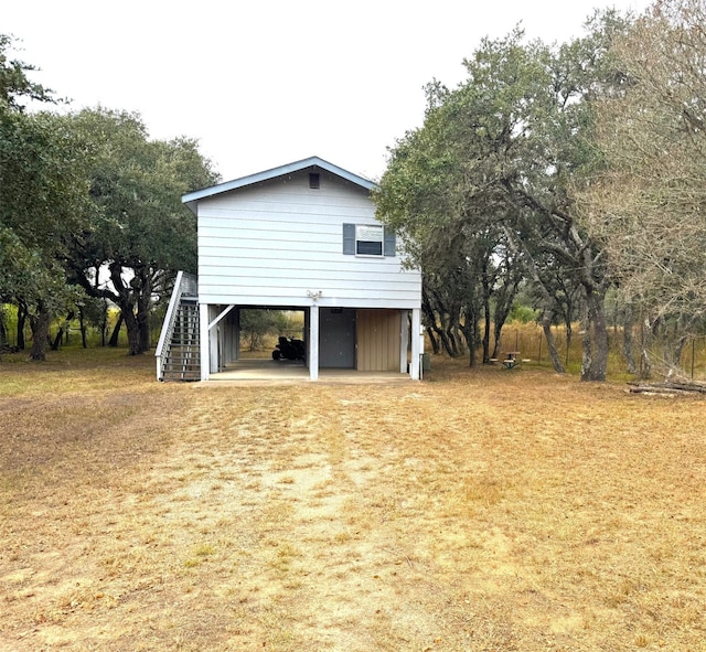 view of home's exterior with a lawn and a carport