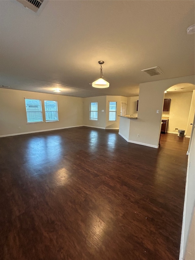 unfurnished living room with dark hardwood / wood-style floors and plenty of natural light