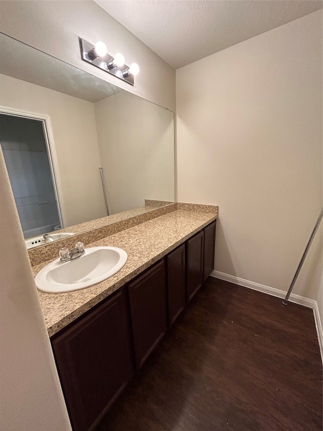 bathroom featuring hardwood / wood-style flooring, vanity, and a textured ceiling